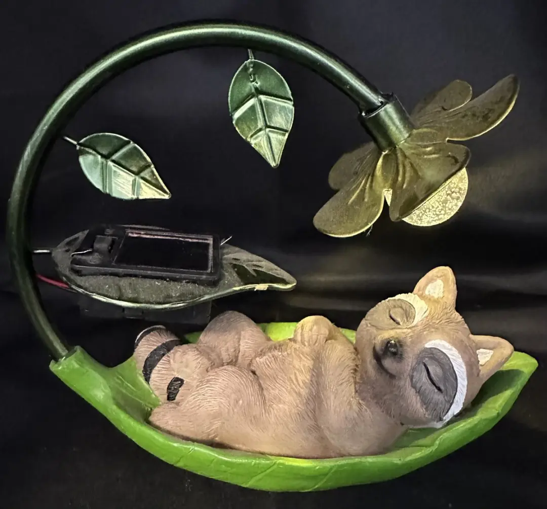 Polyresin solarlamp "slapende wasbeer" met metalen bloem